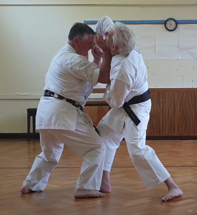 Tori drops weight to collapse Uke while maintaining wrist and head control